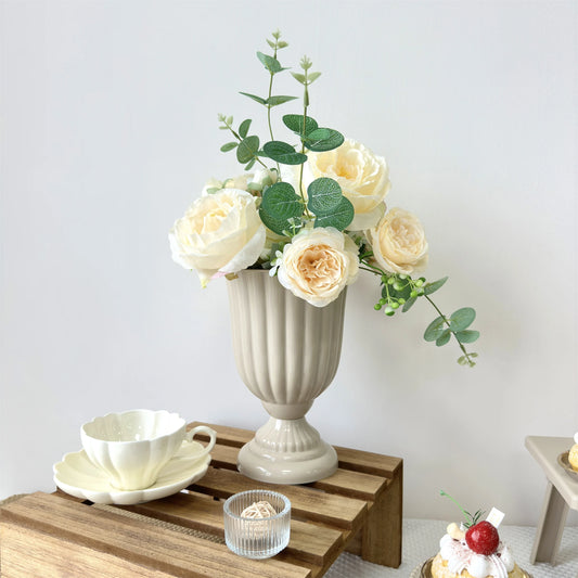 Retro red plastic flower vase on dining table with dried flower stems