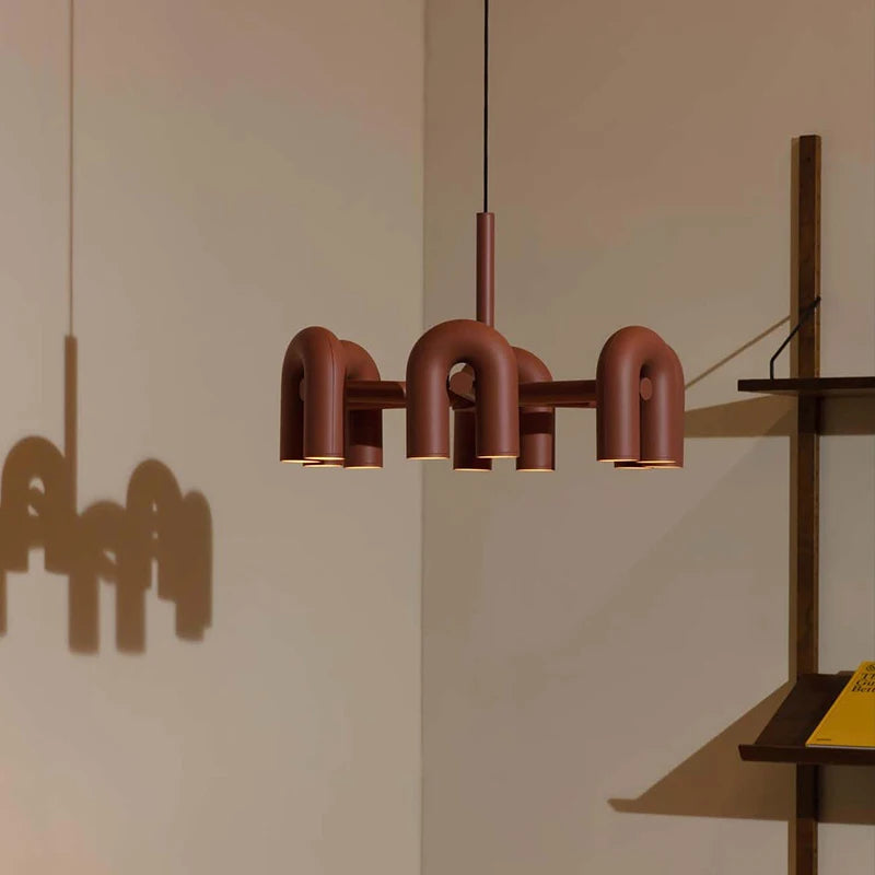 Scandinavian U tube chandelier with chrome arms arcing from a flush plate