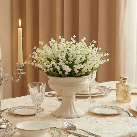 White metal urn vase with fresh garden roses on a French country console table