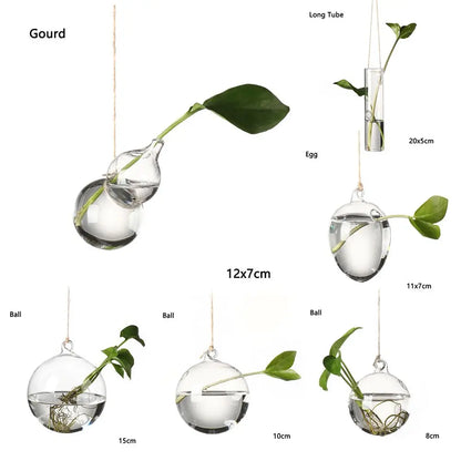 Glass angel hanging vase with small plant indoors