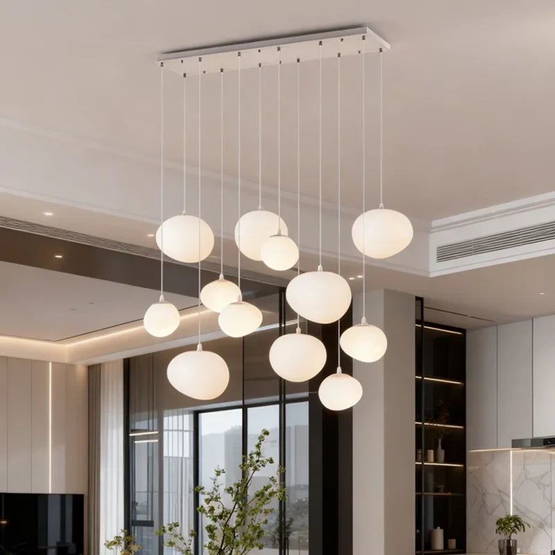 Acrylic stair chandelier lit in warm white down an open stairwell