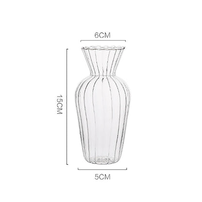 Small Nordic transparent glass vase with single flower stem on work desk