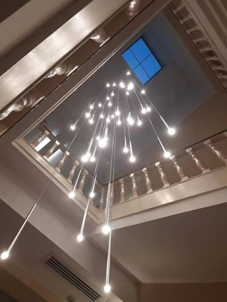 Black aluminum rod chandelier lit in warm light down a stairwell