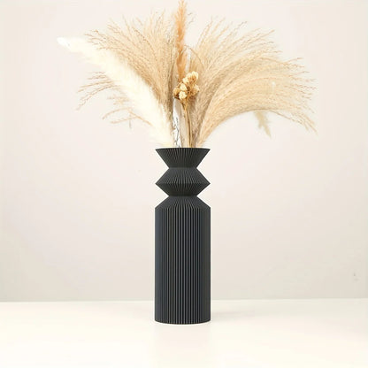 Large Nordic matte black vase holding eucalyptus branch on console