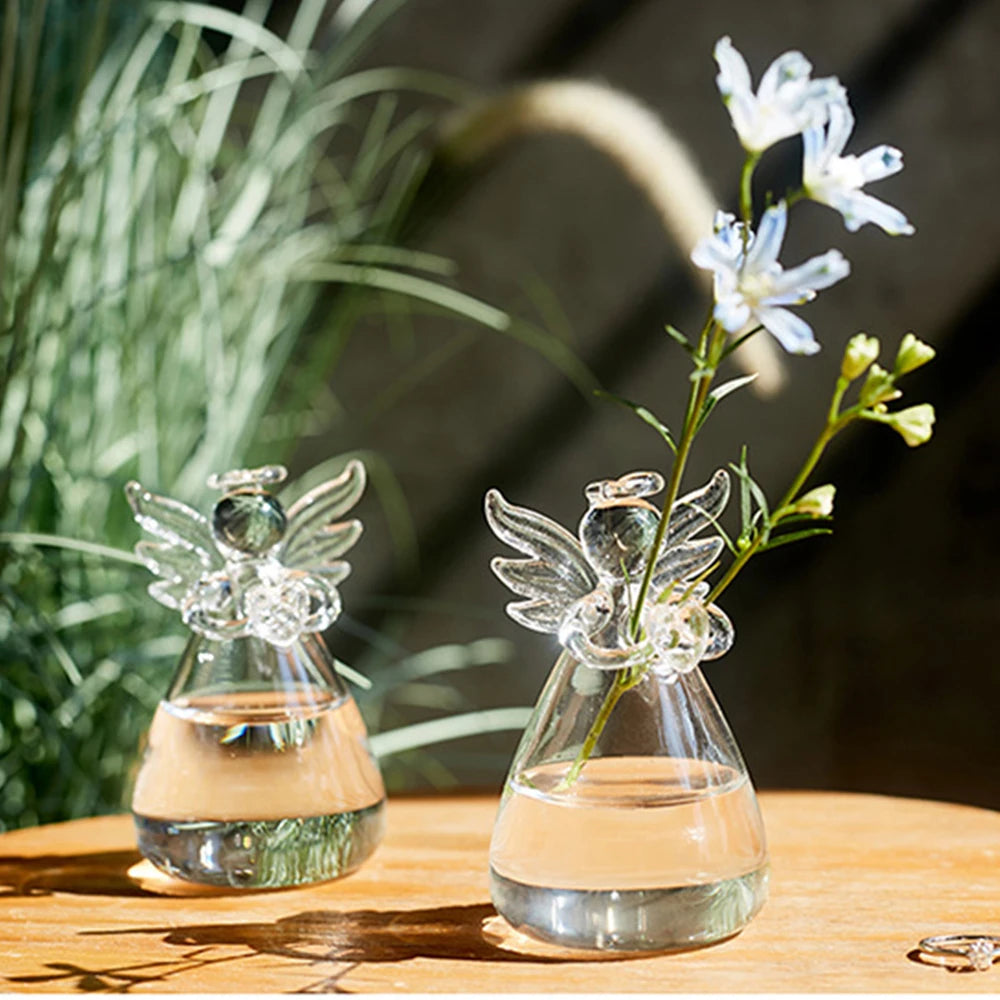 Close-up of angel sculptural form on clear glass hanging hydroponic vase