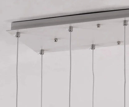 Cold white light across the acrylic shades of a stair chandelier