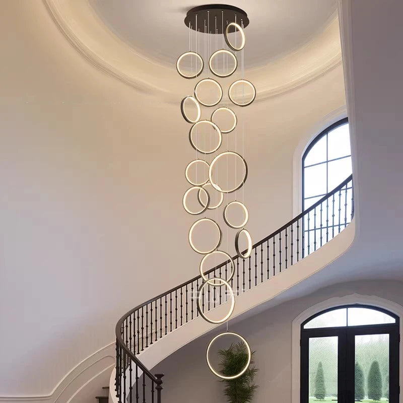 Black framed acrylic chandelier lit in warm white above a table