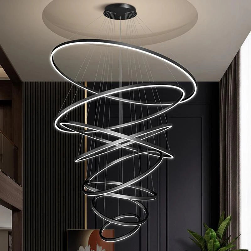 Gold ring chandelier with eight acrylic rings for a tall stairwell
