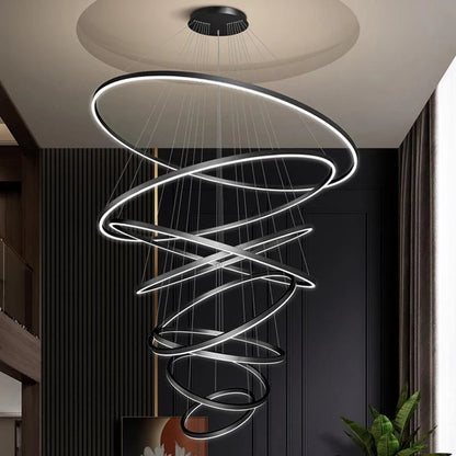 Gold ring chandelier with eight acrylic rings for a tall stairwell