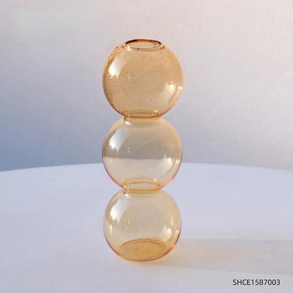 Orange-S terrarium vase with layered sand and moss composition on bedroom windowsill