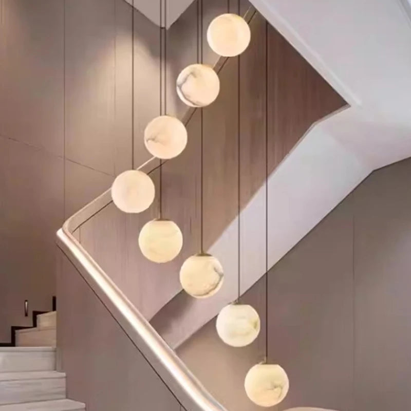 Twenty four head acrylic rod chandelier in gold for a tall stairwell void