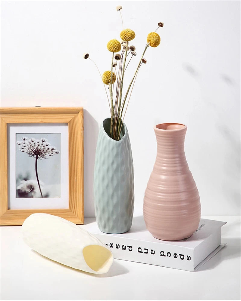 Set of three white Nordic plastic vases in different shapes on home shelf