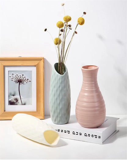 Set of three white Nordic plastic vases in different shapes on home shelf