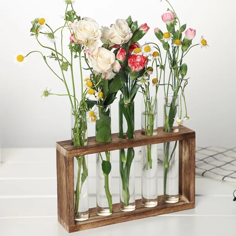 Close-up of glass tubes holding herb cuttings in natural wooden stand