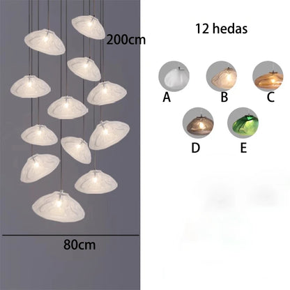 Scattered glass drop chandelier filling a tall stairwell volume