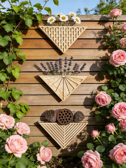 Large geometric triangle wall planter with trailing plant on balcony wall
