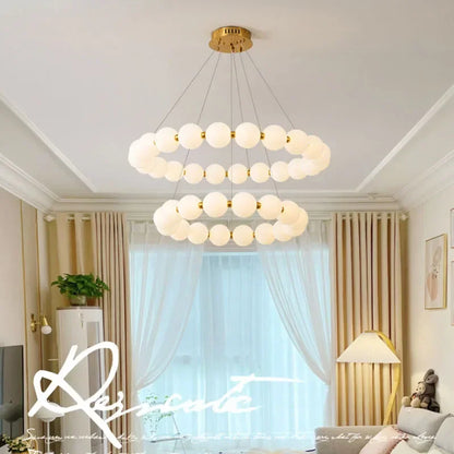 White bead chandelier washing light upward from a shadeless E27 source