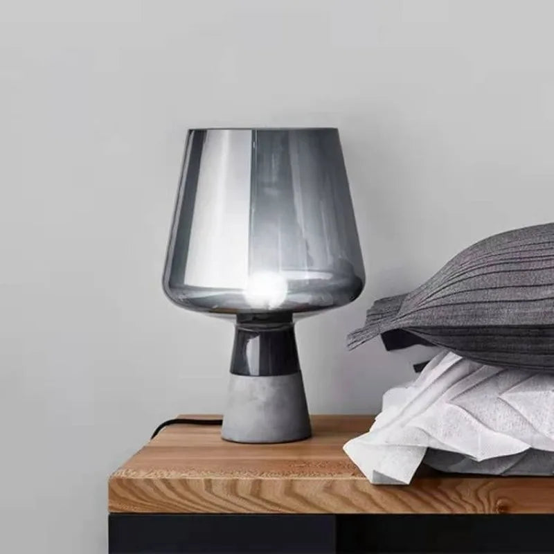Luxury amber glass table lamp glowing warmly on bedroom nightstand