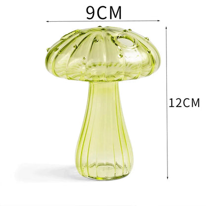 Red mini mushroom glass vase styled on mossy wooden plank surface