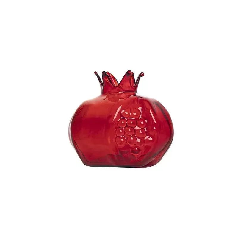 Pomegranate shaped glass vases filled with water and green stem cuttings in natural sunlight