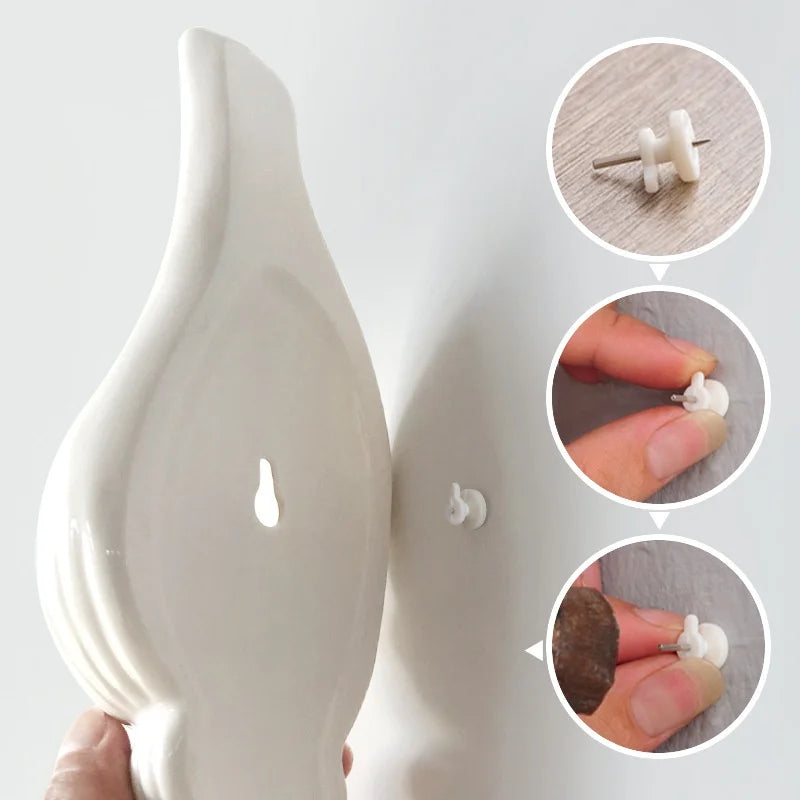 Modern ceramic seashell wall vase mounted in entryway with single stem flower