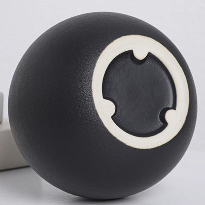 Close-up of smooth black matte ceramic ball vase showing surface texture