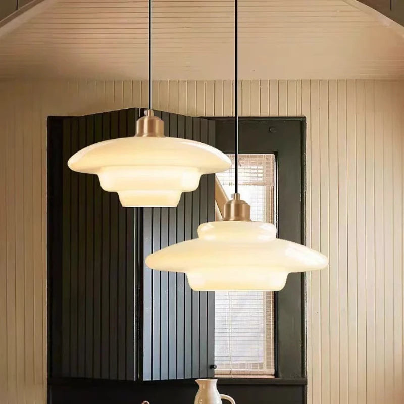 Hot bent milk glass chandelier shade on a slim cord pendant