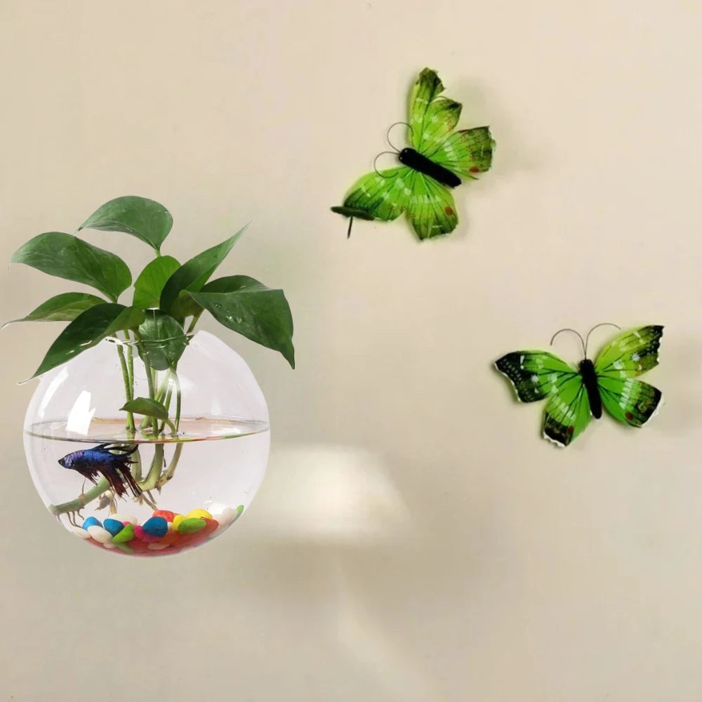 Three sizes of spherical glass wall vases mounted together on white wall