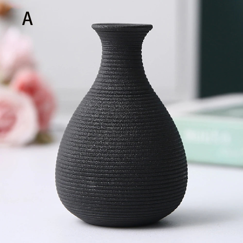 Overhead view of three small black ceramic vases showing different opening shapes