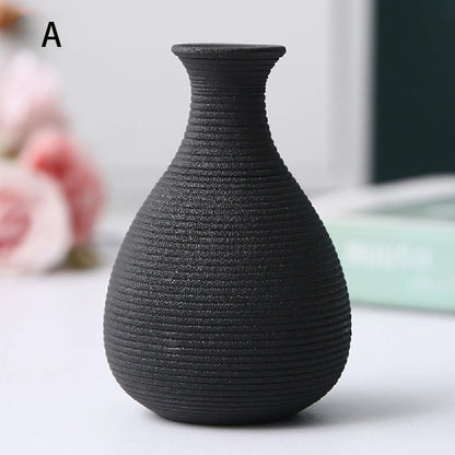 Overhead view of three small black ceramic vases showing different opening shapes
