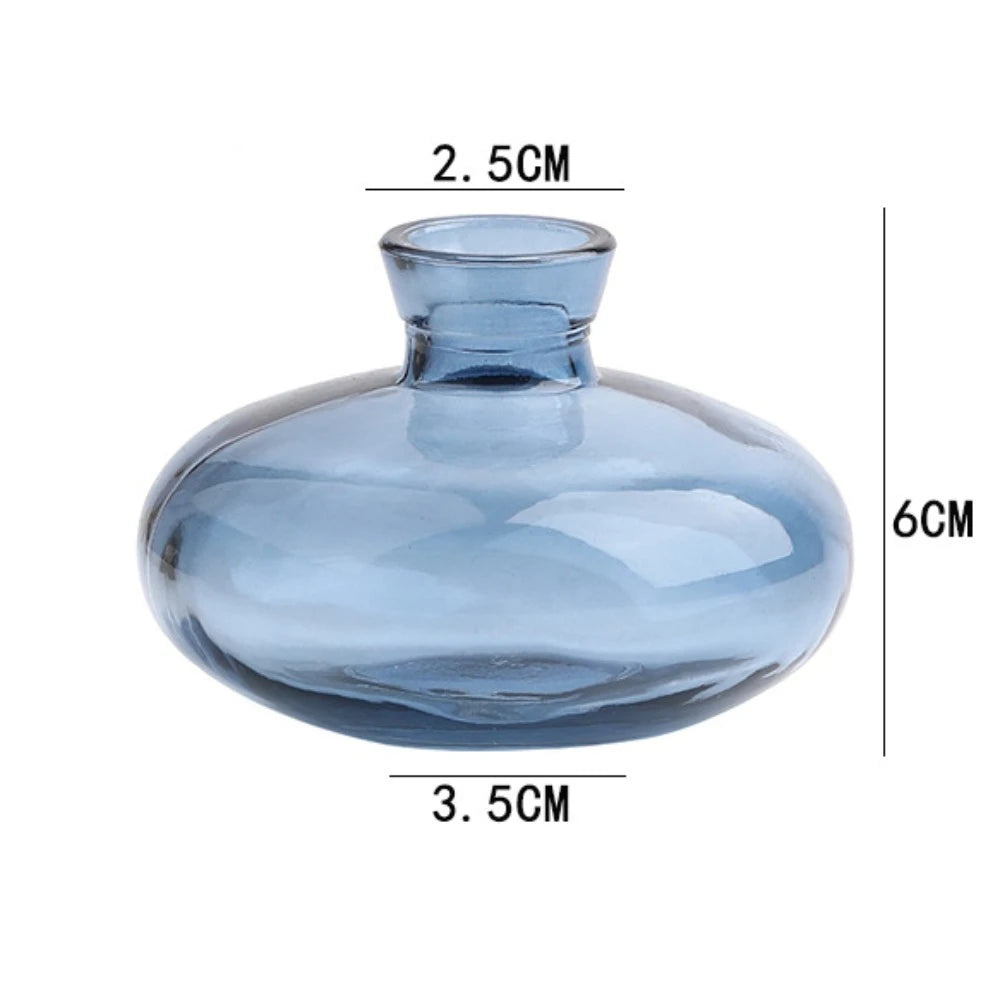 Collection of mini glass flower vases in varied styles on shelf