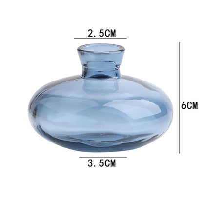 Collection of mini glass flower vases in varied styles on shelf