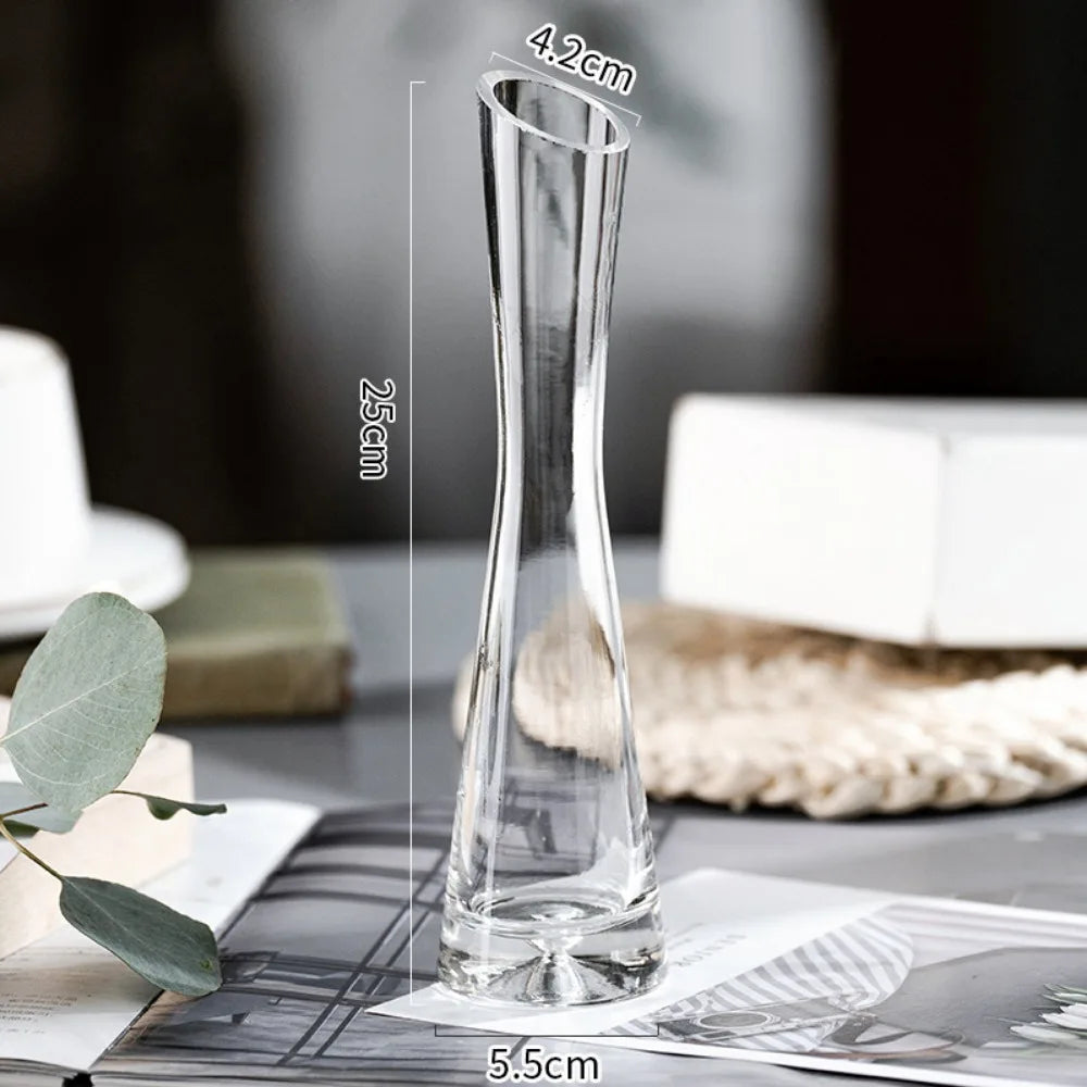 Slanted mouth glass vase holding fresh pink roses on bedside table