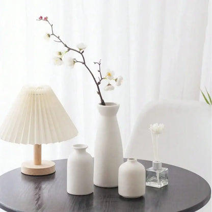 White bohemian ceramic vase trio arranged together on dining table