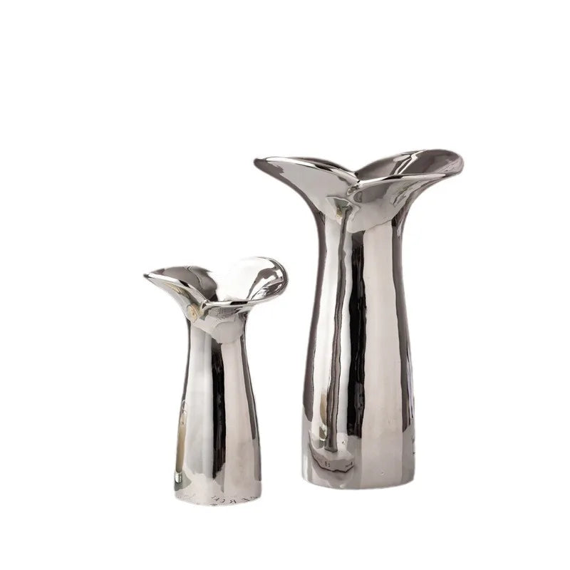Electroplated wabi-sabi vase holding single dried stem on minimalist white floating shelf