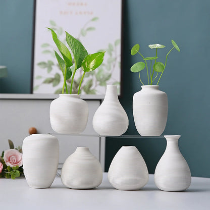 Small black ceramic vase style C with straight cylindrical form on minimalist white shelf