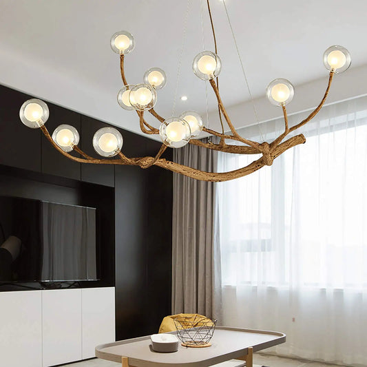 Wood branch chandelier holding twelve clear glass globe shades at mixed heights