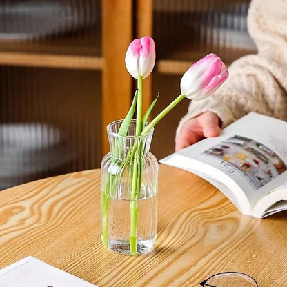 Mini striped glass vase with dried pampas grass on wooden surface