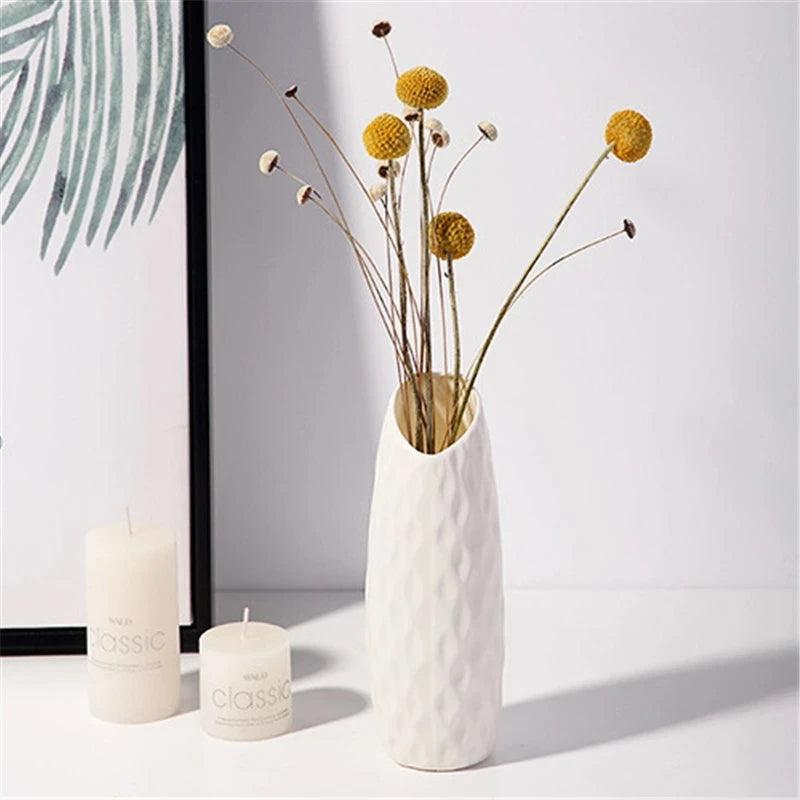 Nordic bottle vase in white plastic with dried pampas grass on wooden desk