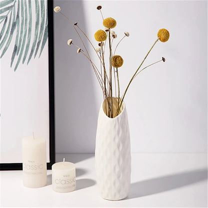 Nordic bottle vase in white plastic with dried pampas grass on wooden desk