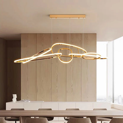 Linear LED pendant light in gold finish, 130 cm length, installed above a dining table