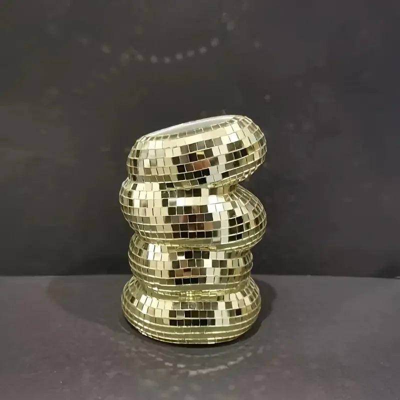 Disco ball glass vase with small flower stems on styled side table