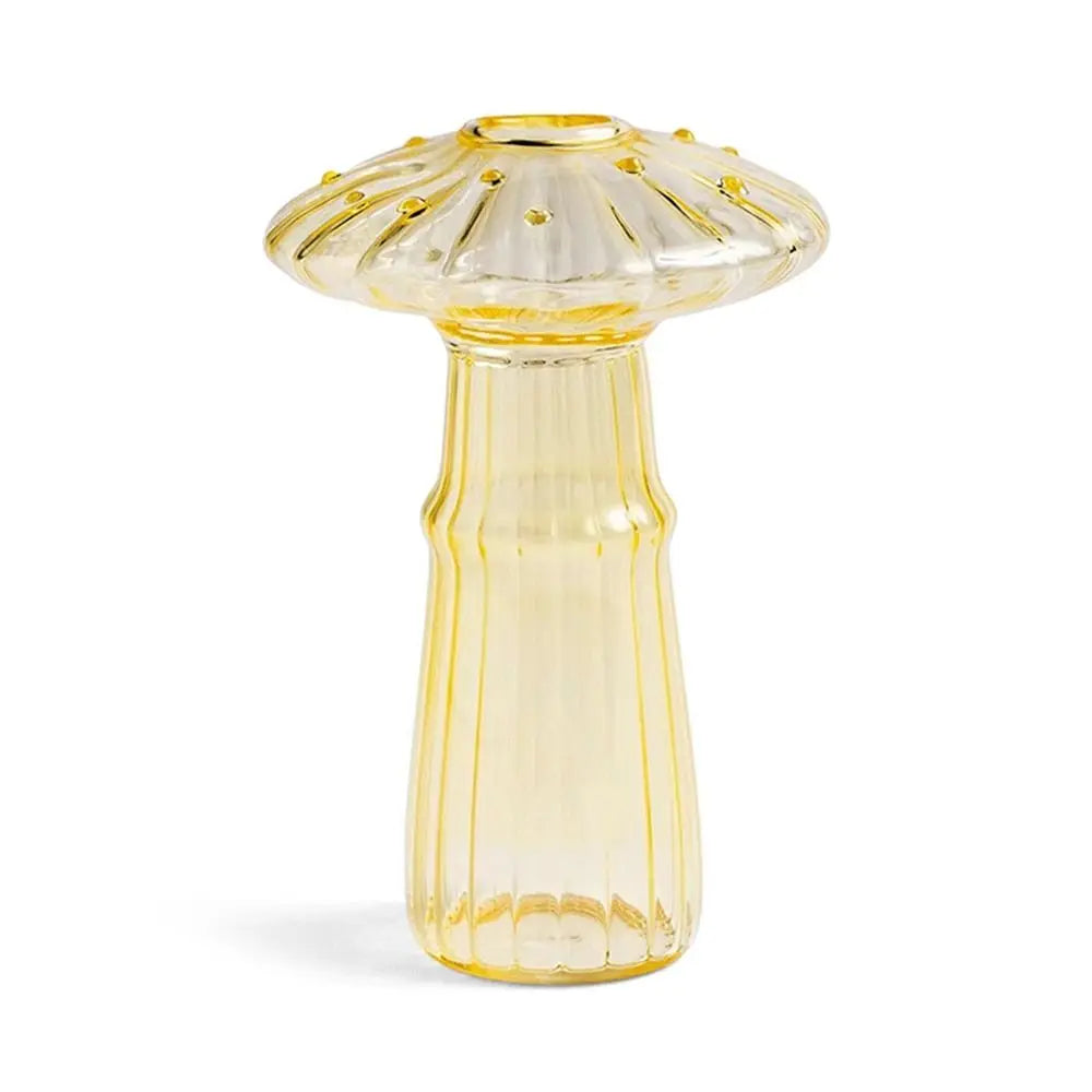 Side view of light green mushroom glass vase with single eucalyptus stem