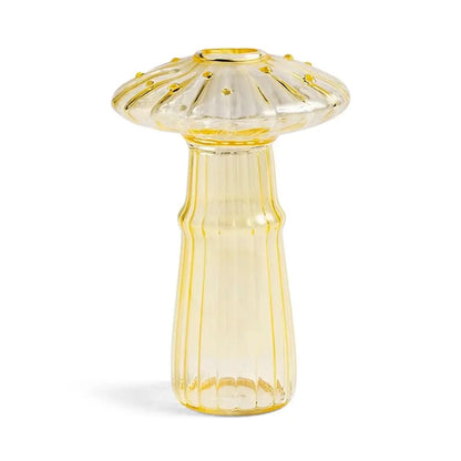 Side view of light green mushroom glass vase with single eucalyptus stem