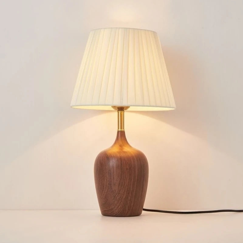 Japanese walnut vase table lamp casting warm ambient glow on bedside table
