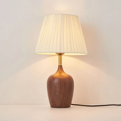 Japanese walnut vase table lamp casting warm ambient glow on bedside table