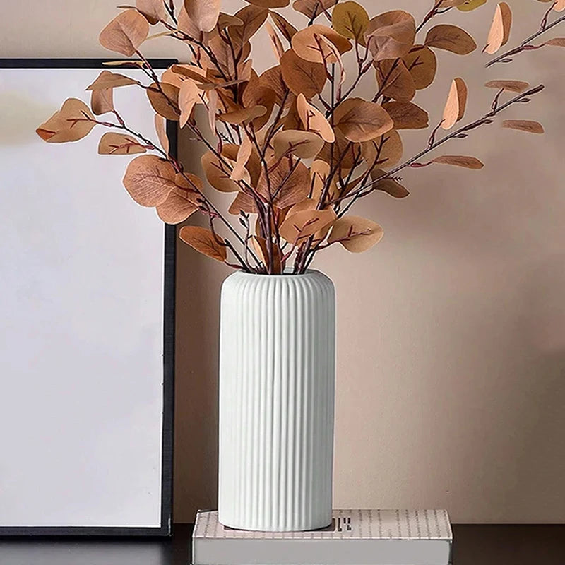 Black striped plastic vase with ceramic-look surface on modern shelf