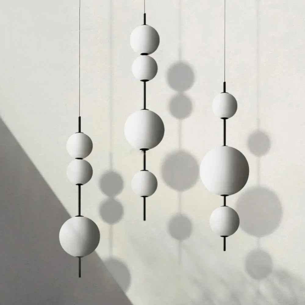 White glass ball chandelier with opal spheres stacked down a slender stem