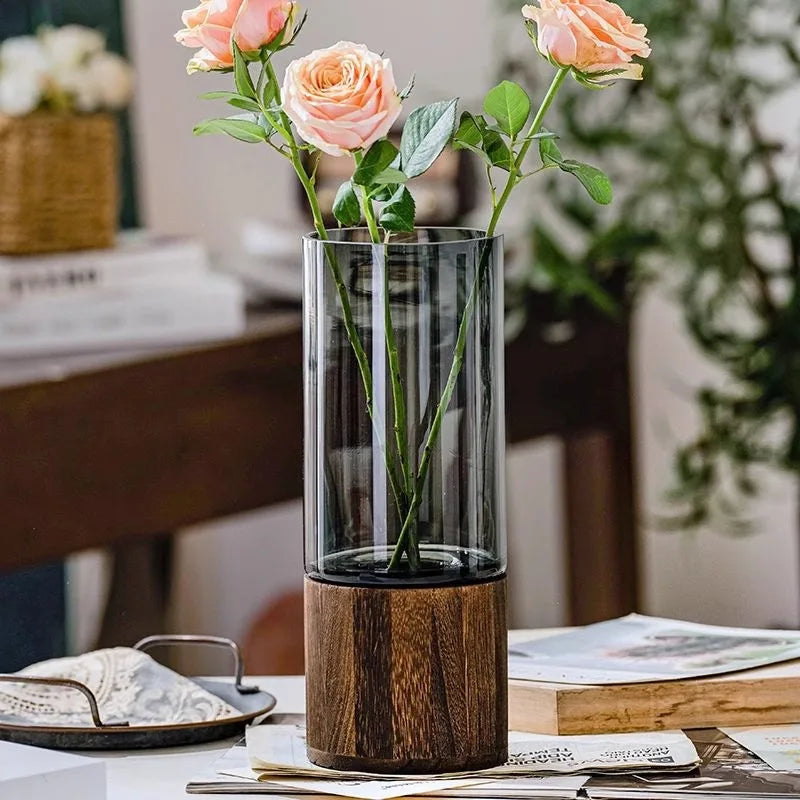 Style C glass bud vase with round wooden base on a minimalist desk display